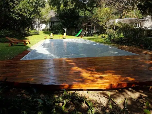 designer pool covers A wooden deck with a covered swimming pool.