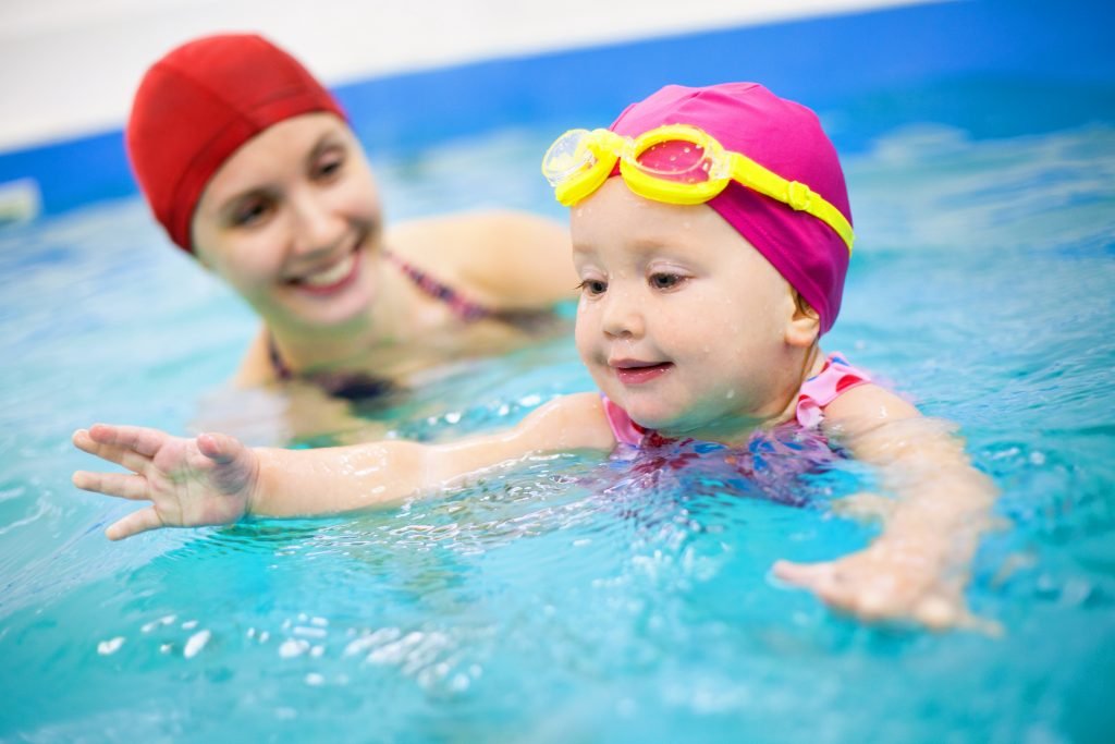 designer pool covers A baby in a swimming pool with emphasis on safety precautions.