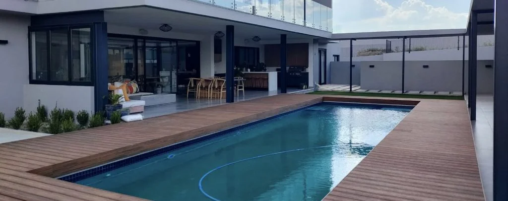 designer pool covers A swimming pool with pool covers in the backyard of a house.