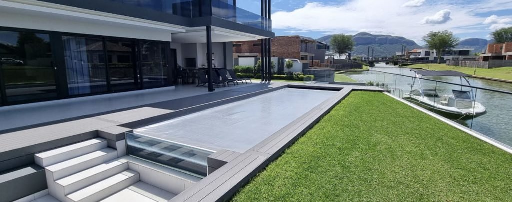 designer pool covers A house with a swimming pool in the back yard.