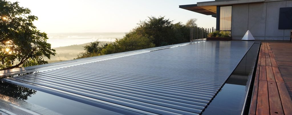 designer pool covers A swimming pool on a deck with pool covers overlooking the ocean.