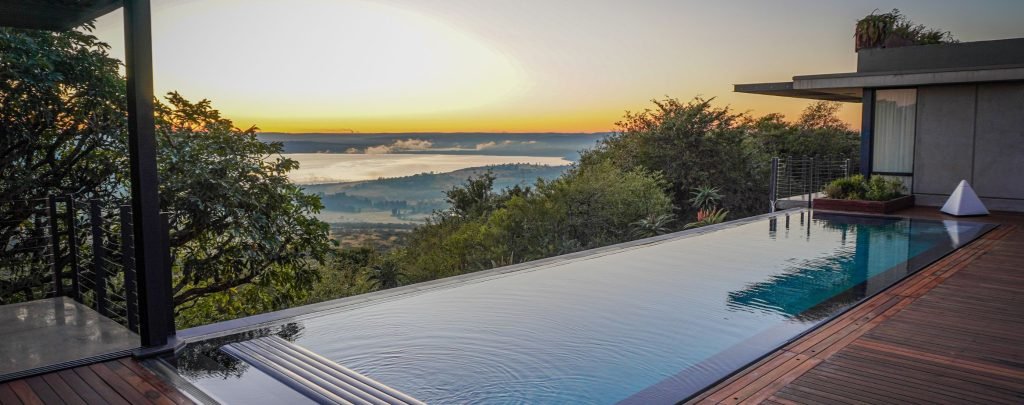 designer pool covers A swimming pool with a sunset view.