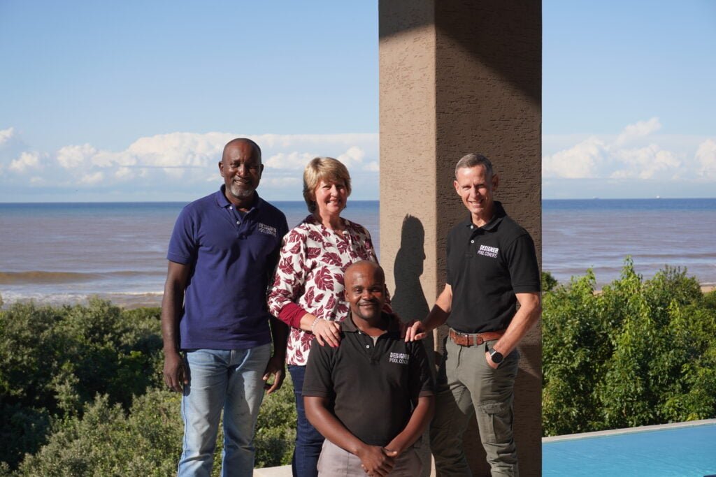 designer pool covers A group of people posing for a photo near a designer pool in Durban.