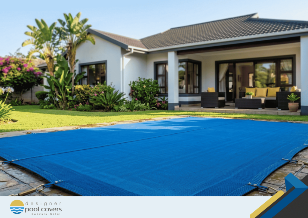 A modern house with a patio and outdoor seating, featuring a blue safety pool cover secured over a backyard swimming pool.